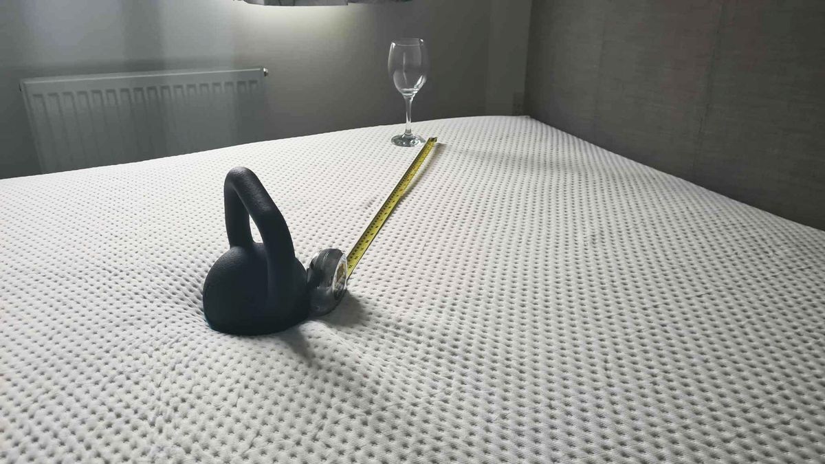 A kettlebell, a wine glass and a tape measure on the Emma Luxe Cooling Mattress