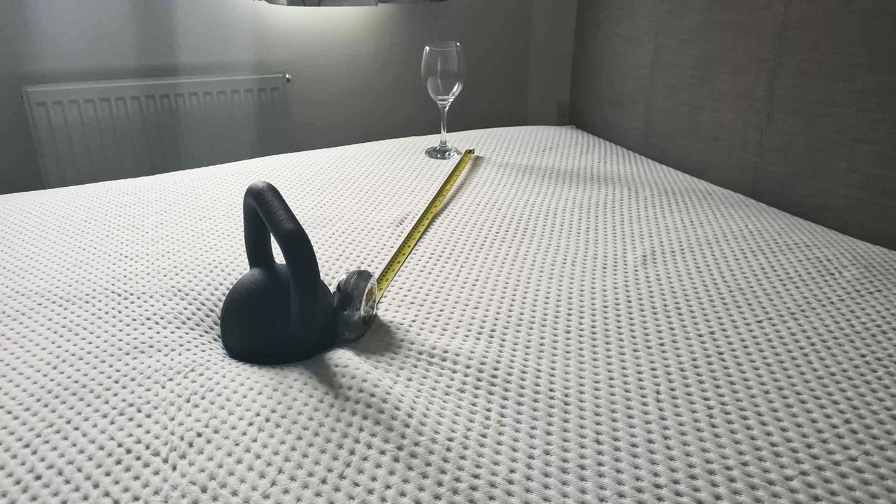 A kettlebell, a wine glass and a tape measure on the Emma Luxe Cooling Mattress