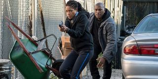 Black And Blue Naomie Harris and Tyrese Gibson sneak along a chain link fence