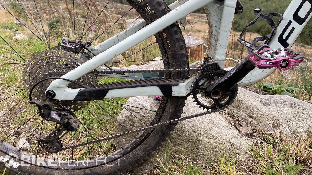 Focus Jam 6.9 trail bike leaning against a rock next to a singletrack trail