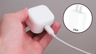 Apple 20W charger held in a hand