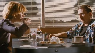 Amanda Plummer drinking coffee in a booth with Tim Roth in the opening scene of Pulp Fiction