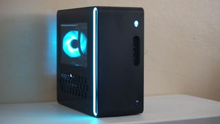 An angled wide-angle view of the Alienware Aurora gaming desktop on a desk in a darkened room