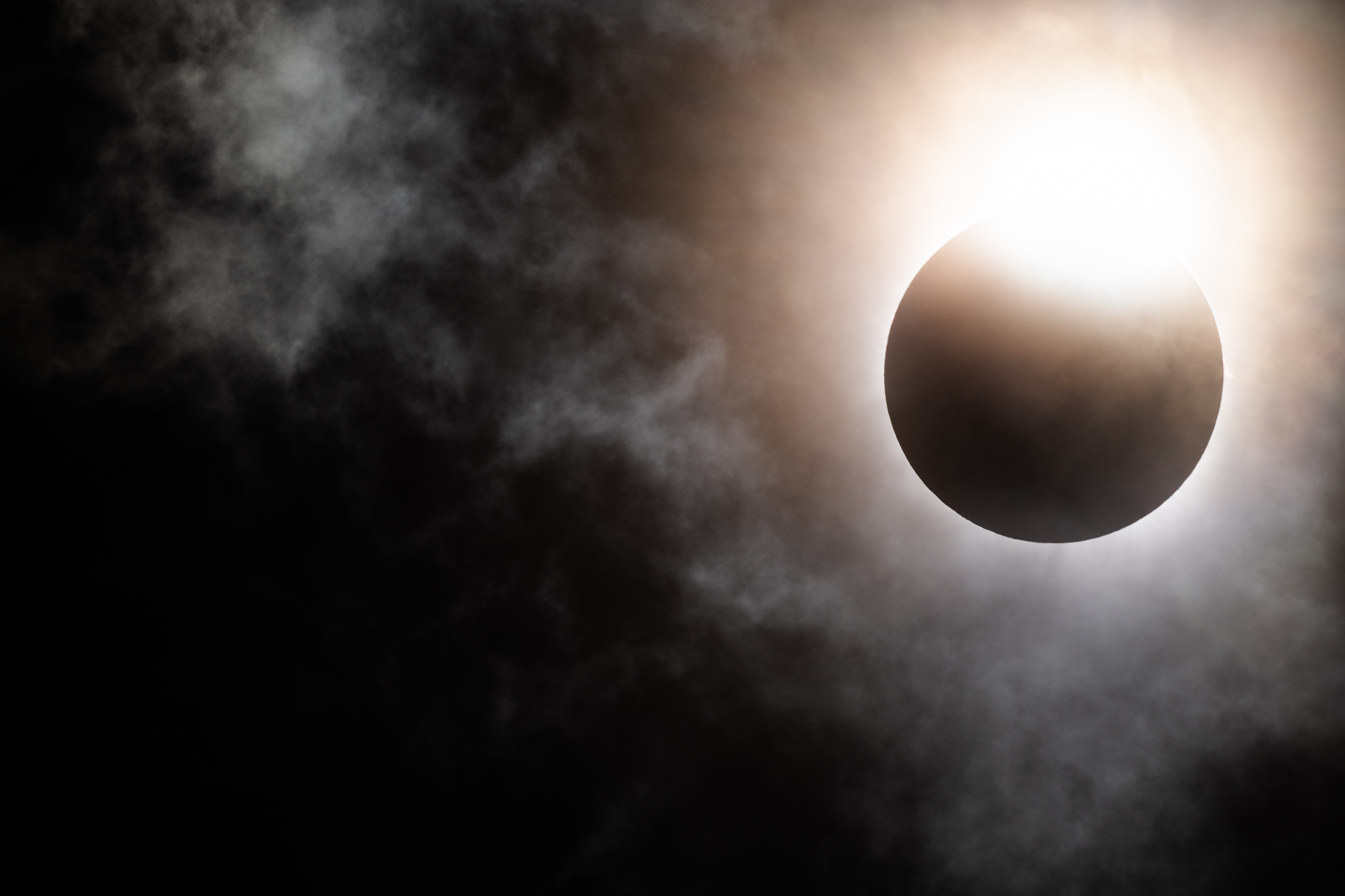 2024 年 4 月 8 日にテキサス州ブレイディで起こる皆既日食中に、月が太陽の地平線の下に沈み始めます。