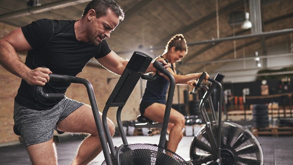 a photo of a man and woman on an assault bike
