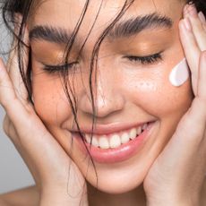 Woman smiling with face cream on