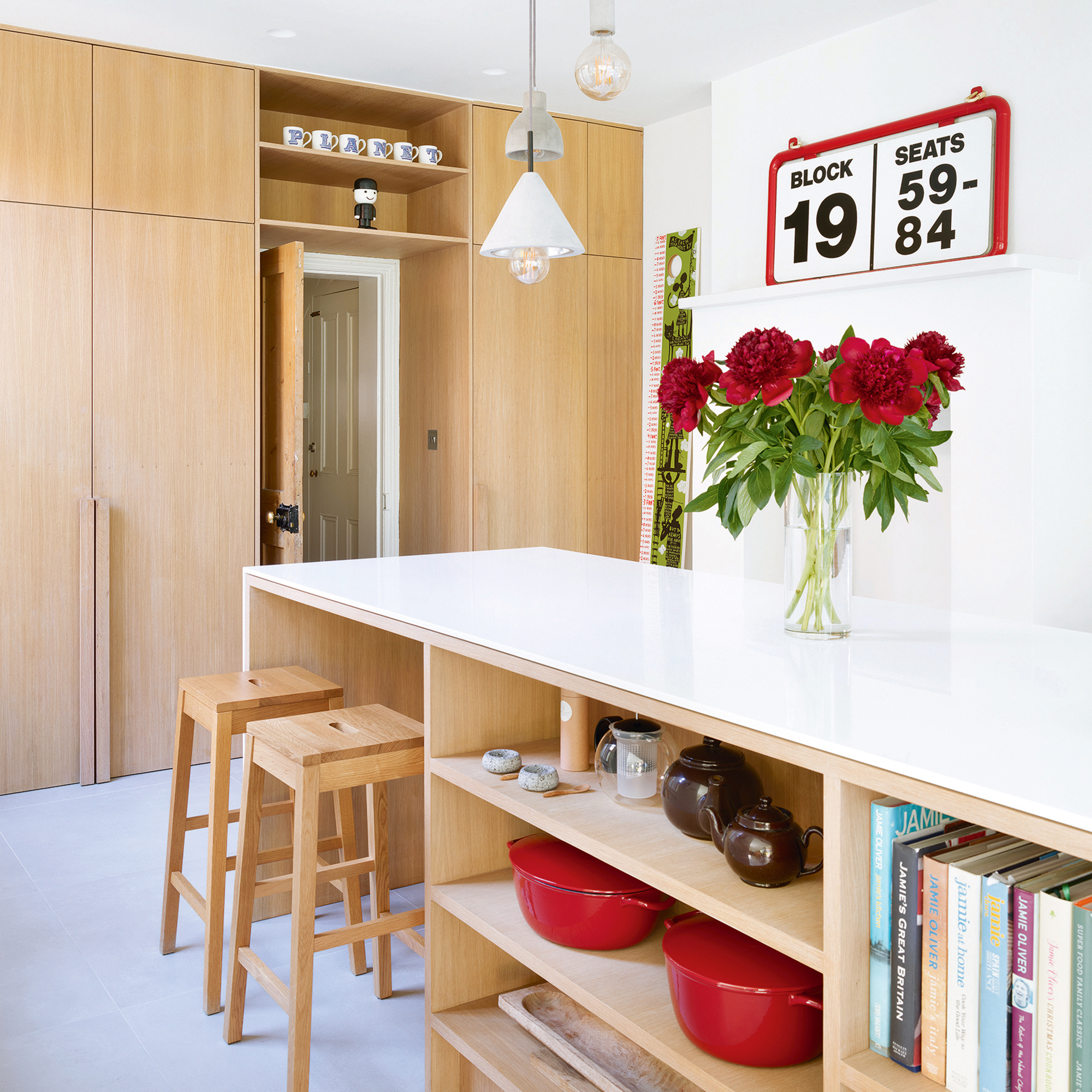 White kitchen with wooden cabinetry and storage built into island