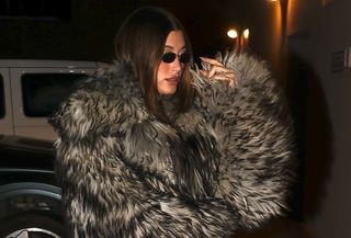 Hailey Bieber wearing fur coat and leggings.