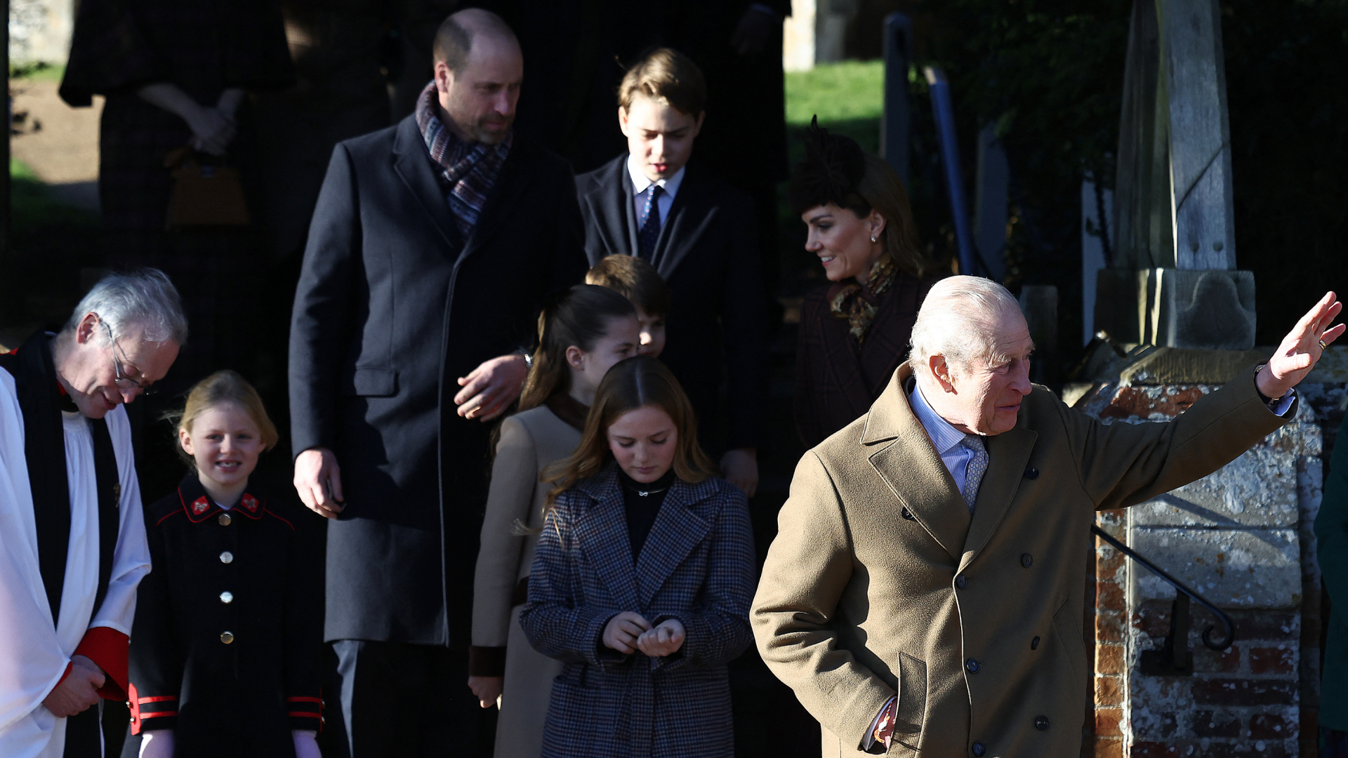 King Charles waving outside church on Christmas with William and Kate behind him