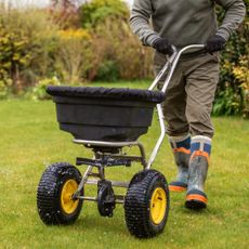 Man fertilizing fall lawn