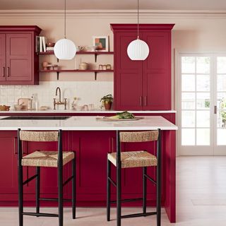 Red kitchen cabinets with white kitchen island and stools