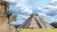A steep pyramid temple at Chichen Itza with a blue sky in the background.