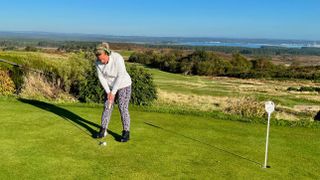 Carly Cummins putting with headphones on