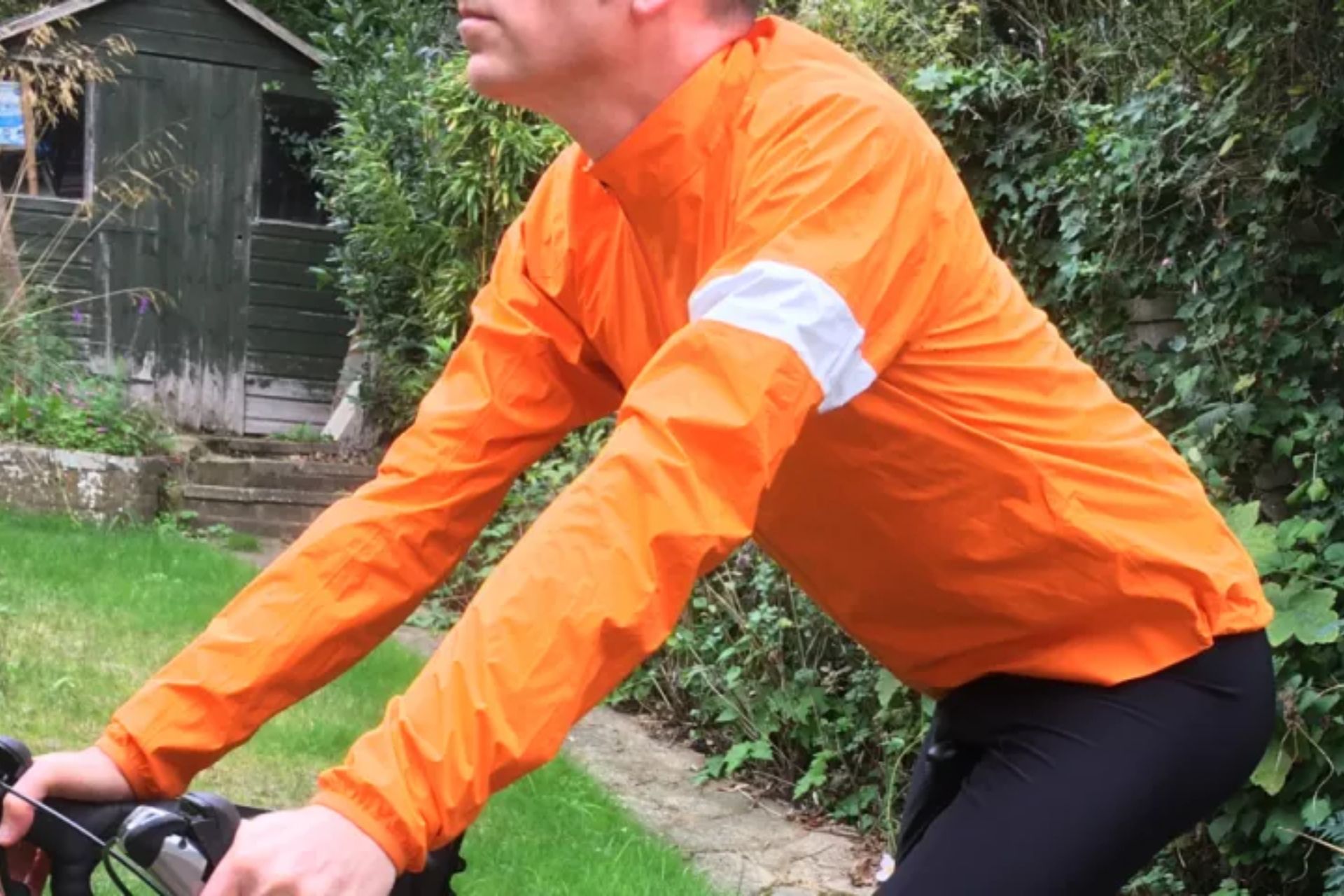 Image shows a rider wearing the Rapha Core Rain Jacket II.