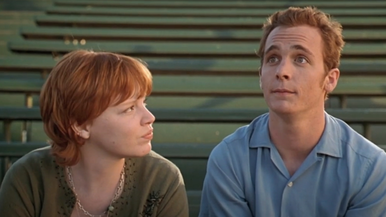 Lauren Ambrose and Ethan Embry sitting on bleachers in Can't Hardly Wait