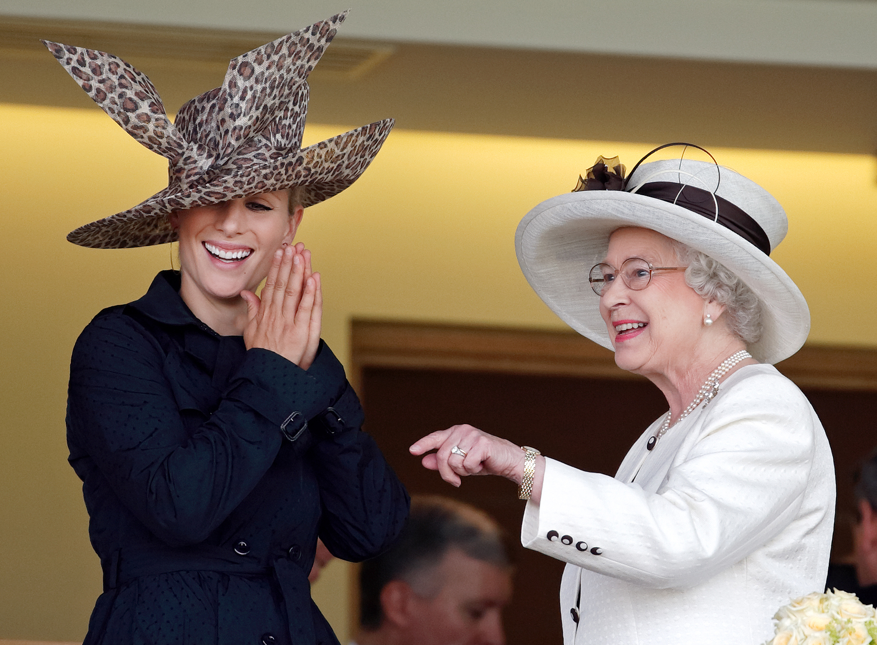 Zara Tindall wearing a black coat laughing next to Queen Elizabeth