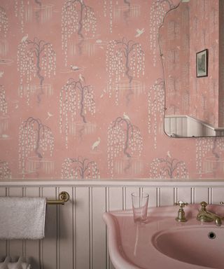 Pink bathroom with pink basin, pink wallpaper, mirror, wainscotting painted white