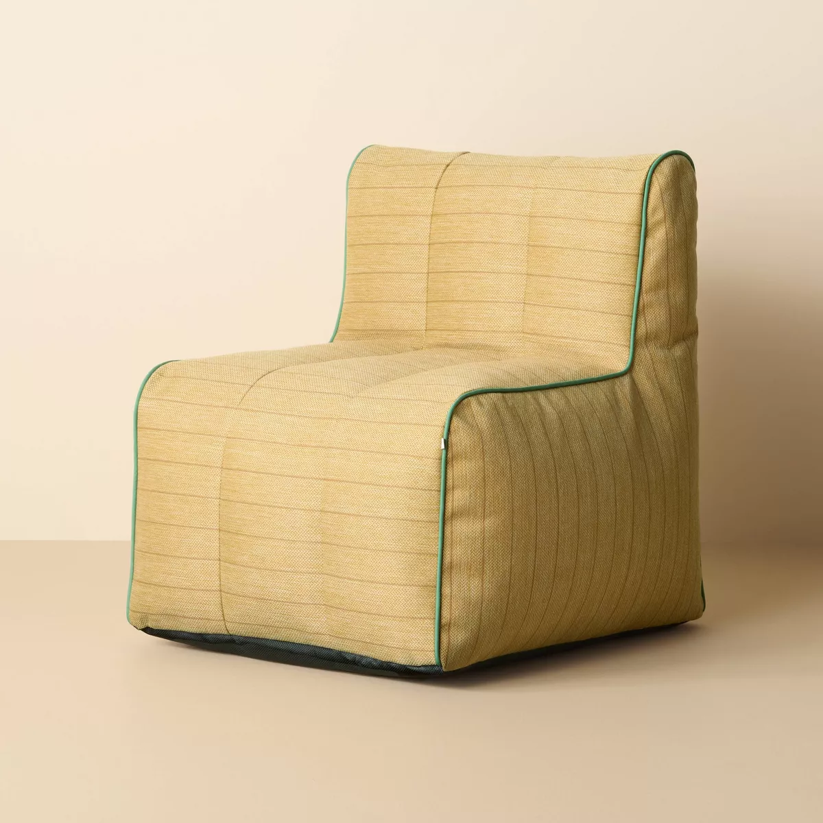 Outdoor chair in neutral fabric with green trim