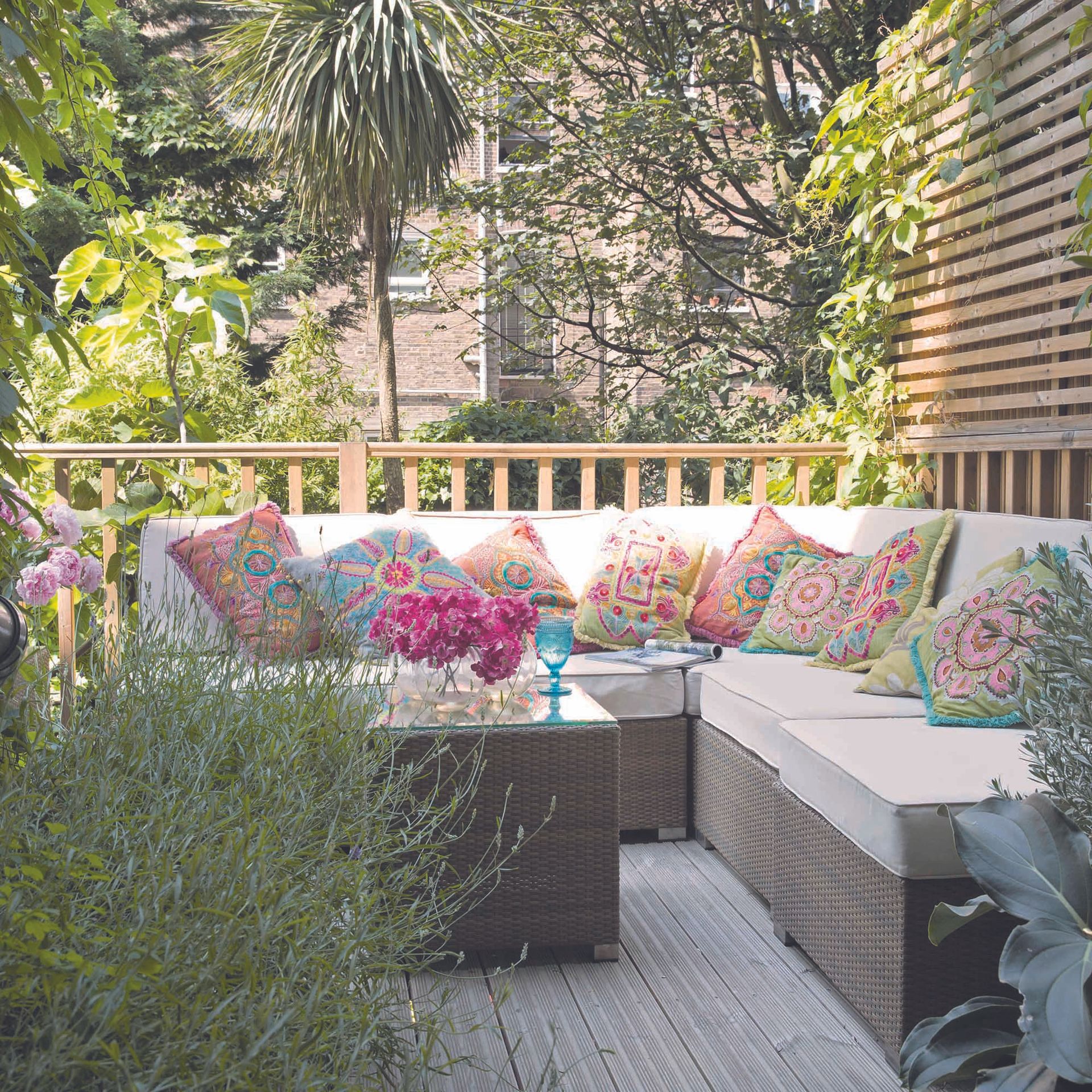 Large outdoor sofa in garden decorated with cushions.