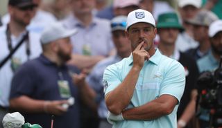 DeChambeau puts his finger to his mouth whilst watching his tee shot