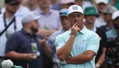 DeChambeau puts his finger to his mouth whilst watching his tee shot