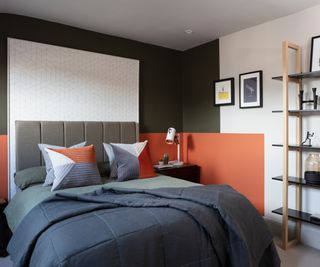 bedroom with colour blocked panels on walls in dark blues and orange