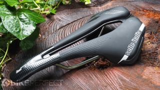An angled top-down view of the Selle Italia X-LR TI316 Superflow showing the cut-out and shoulder bumpers