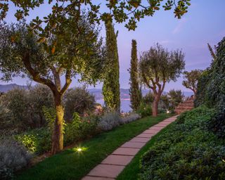 terraced mediterranean garden overlooking sea with path and steps flanked by cypress trees
