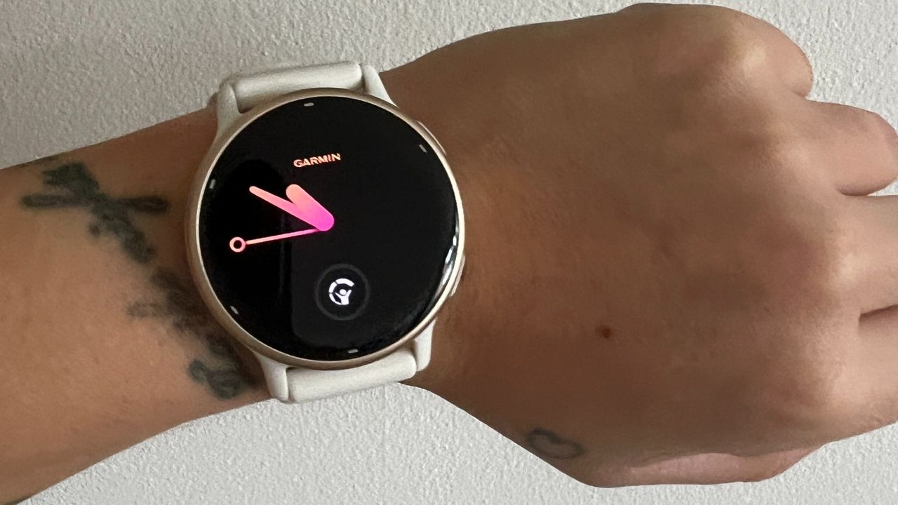 Garmin Vivoactive 5 close up on wrist home screen against white wall
