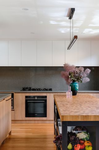 A kitchen with a marble effect kitchen island butcher block