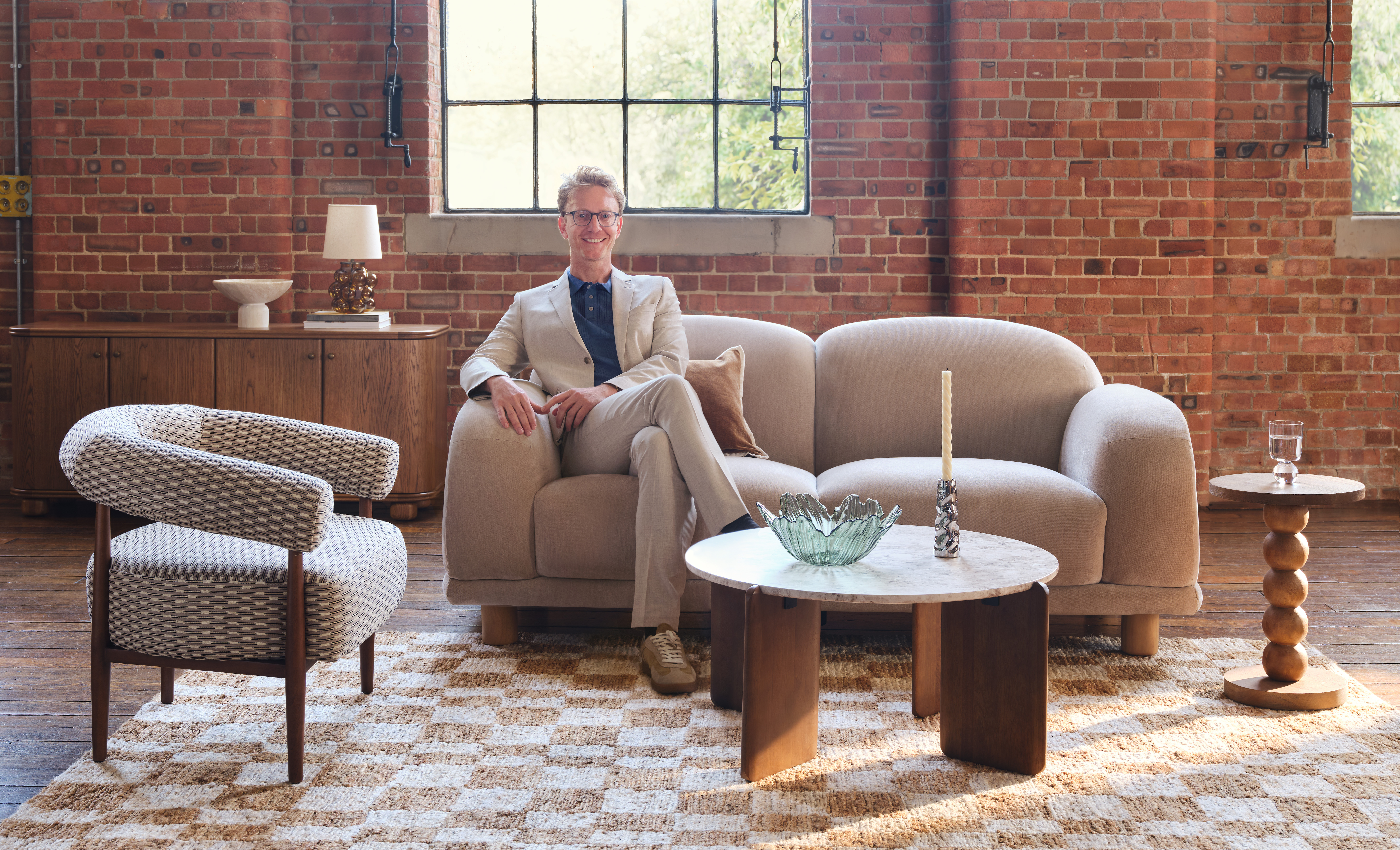 Pip Rich sat on a modern sofa in a modern living room