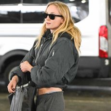 Sophie Turner is spotted at JFK airport in a groutfit, including a bomber jacket and Adidas Samba sneakers.