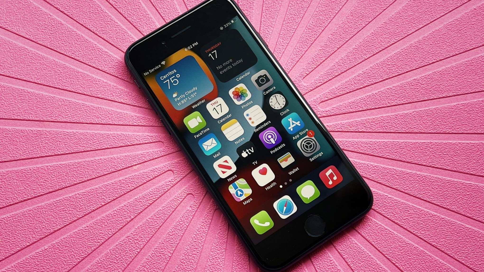 iPhone SE 2022 negro sobre fondo rosa