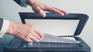 Hands operating a desktop scanner