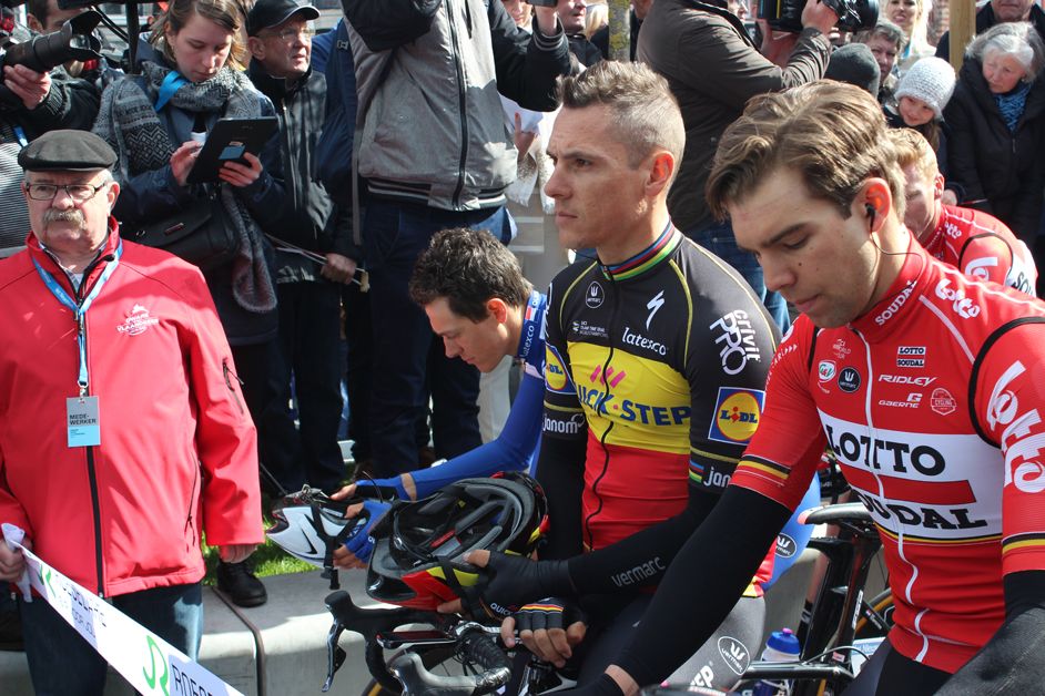 The riders take off their helmets in a tribute to the victims of last year's terror attack in Brussels