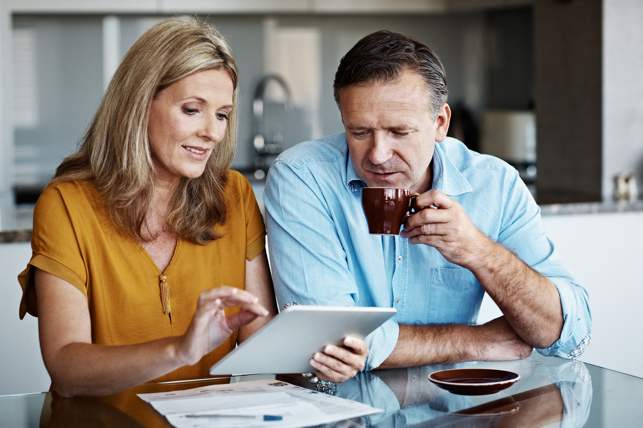 Shot of a mature couple paying their bills online from home