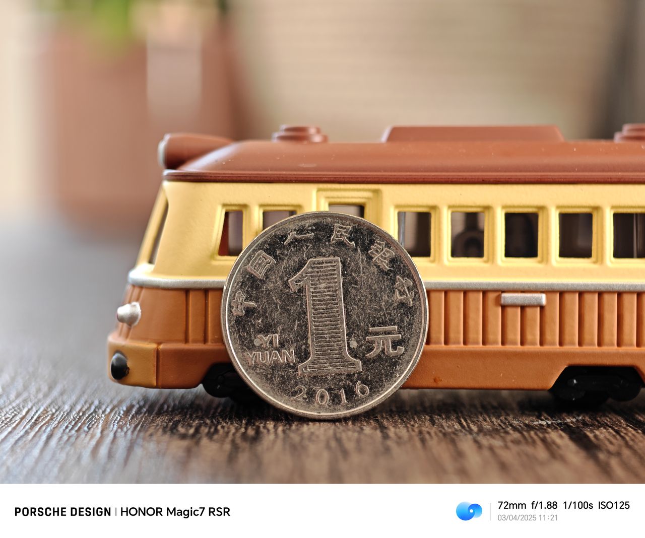 A coin propped up against a train on a wooden table