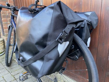 Ortlieb Back Roller Free panniers on a bike against a wooden garage door