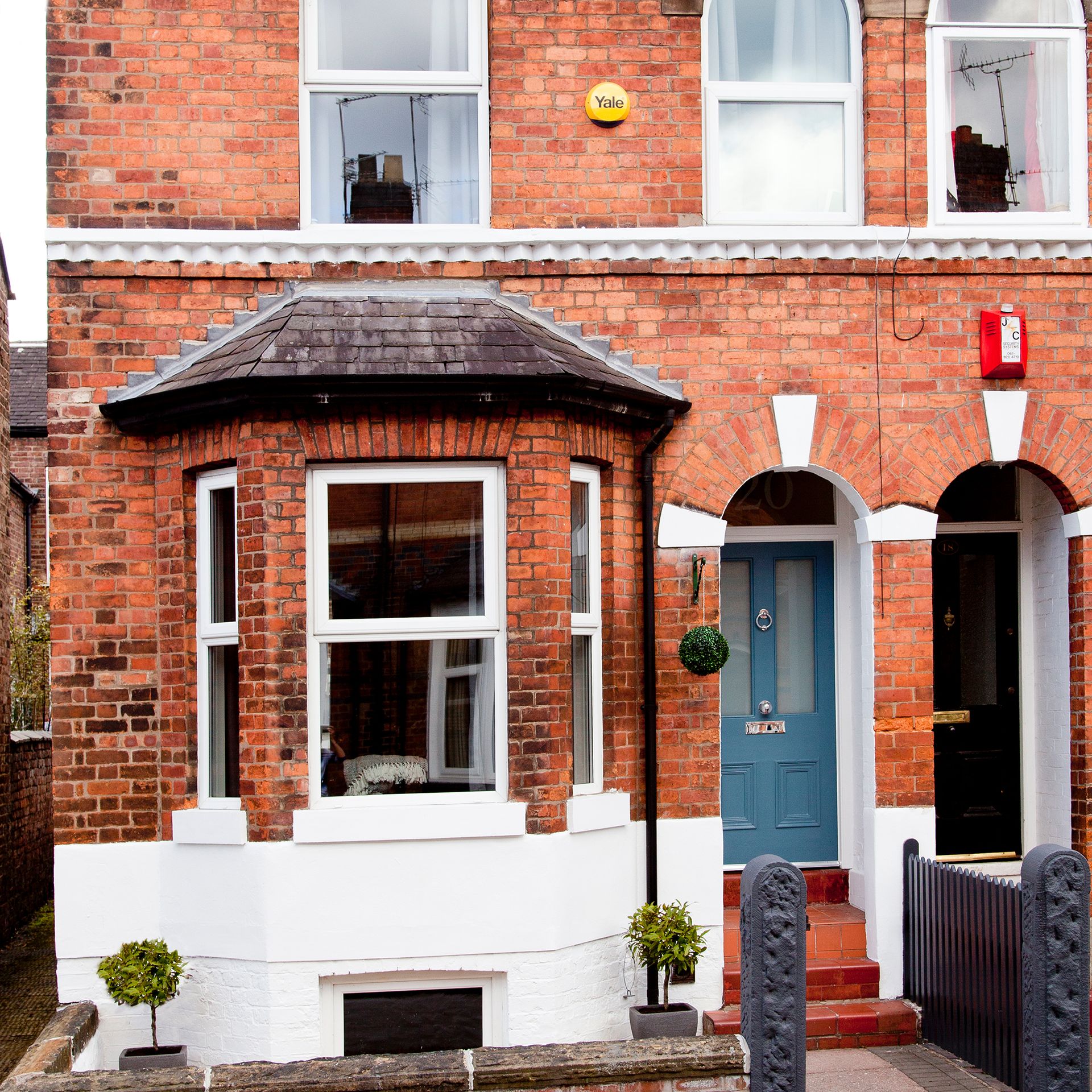 Front of red brick terraced house with bay window