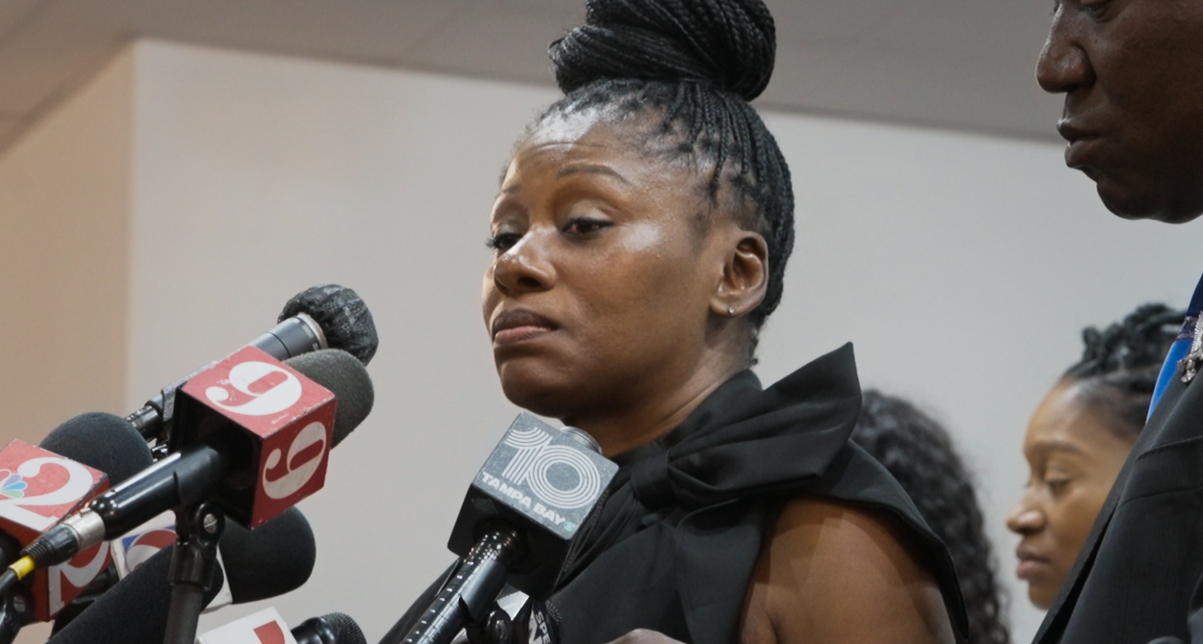 Pamela Dias speaking into several microphones at a press conference in a still from the documentary the perfect neighbor