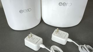 The eero Pro 7 and the eero Max 7 next to each other on a desk with their power adapters