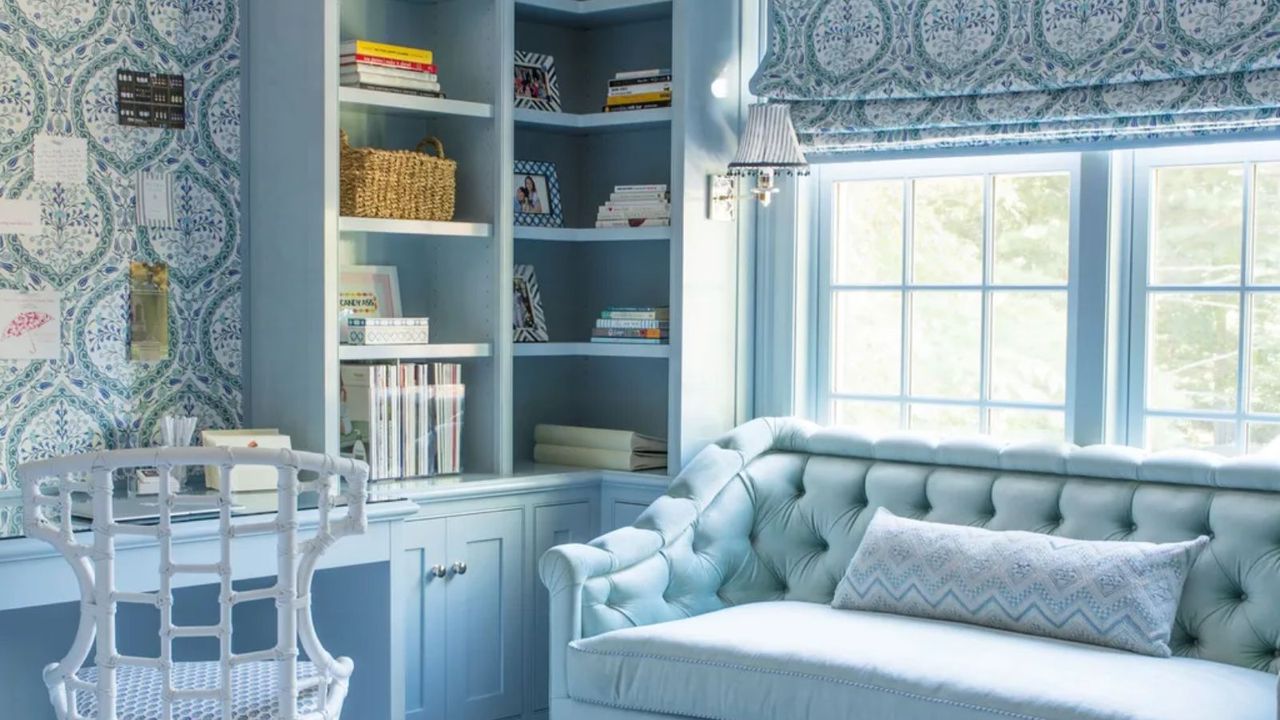 blue color drenched home office with matching wallpaper and patterned blind and a blue couch