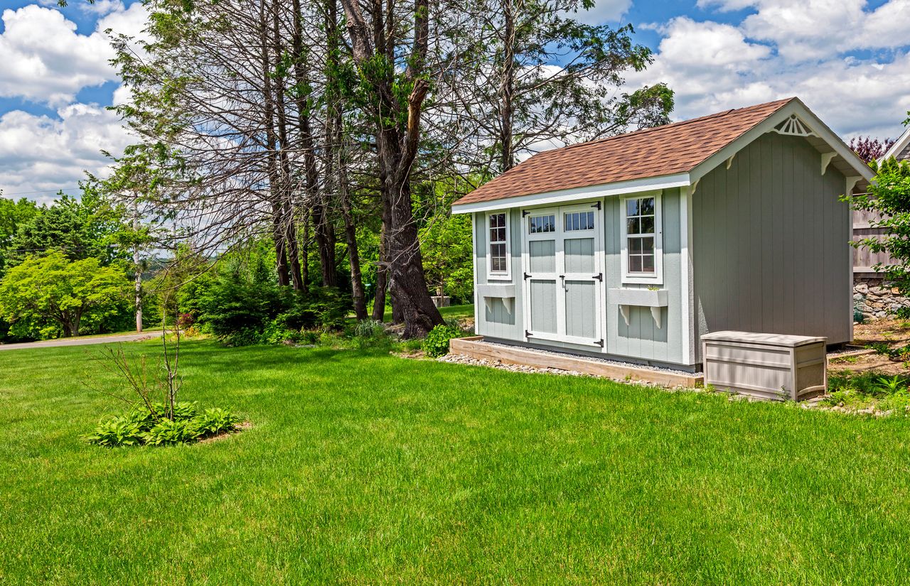 a grey shed in a yard