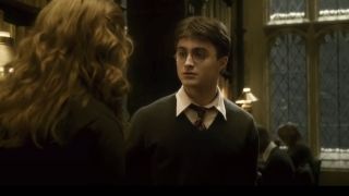 Daniel Radcliffe stands in a daze in front of Emma Watson in Harry Potter and the Half Blood Prince.
