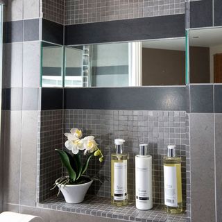 bathroom with grey tiles wall and storage area