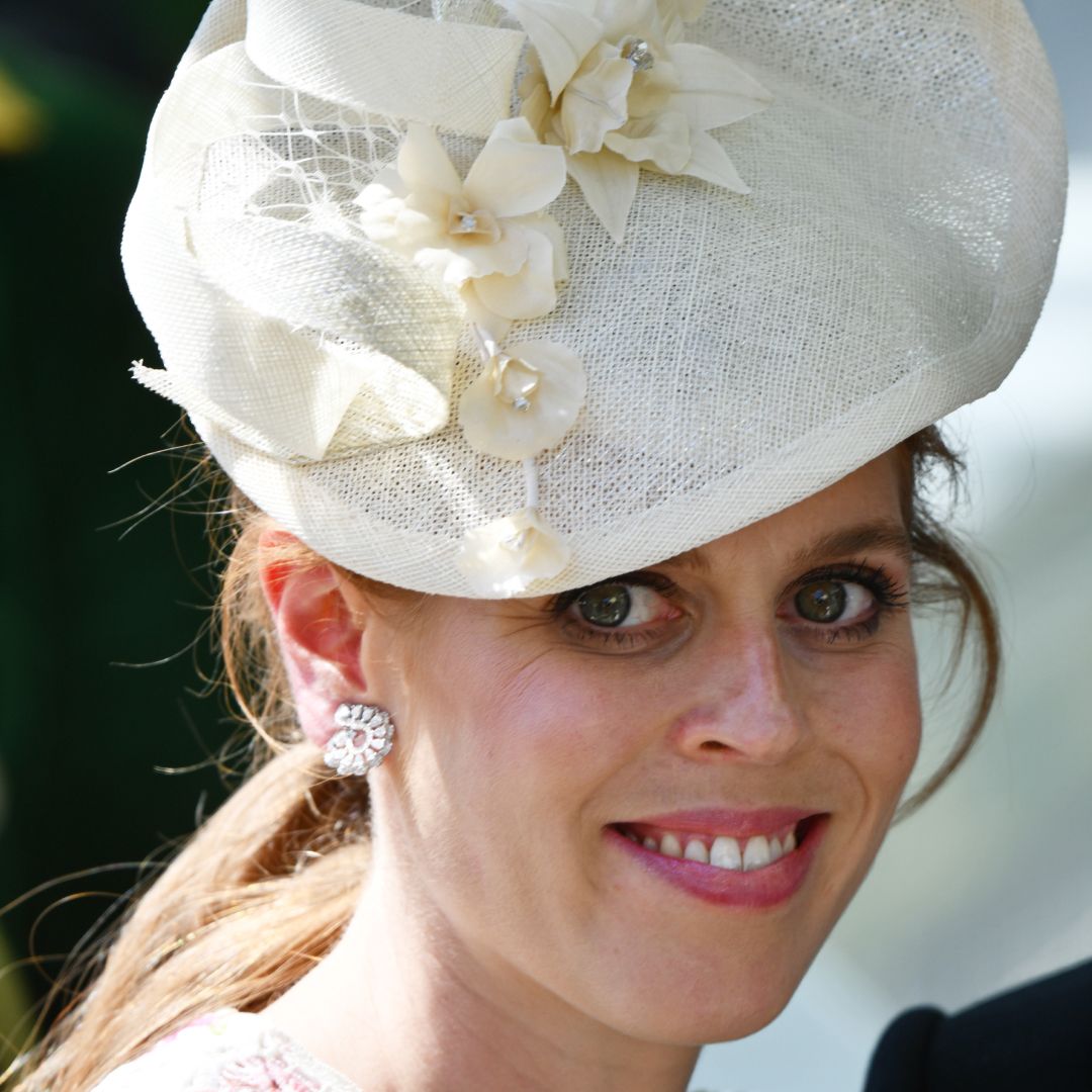 Princess Beatrice smiling wearing a white hat