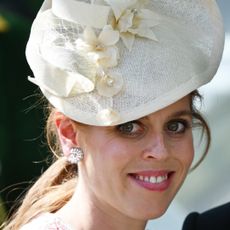Princess Beatrice smiling wearing a white hat