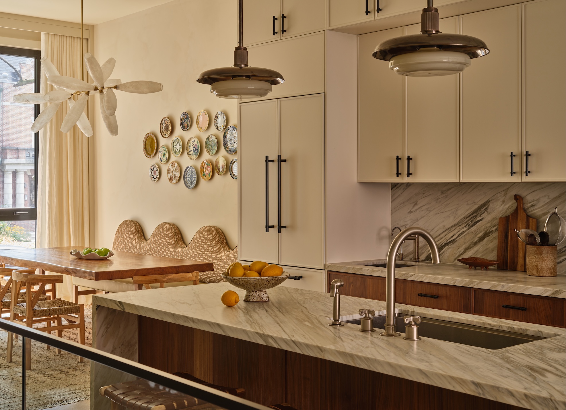 A muted neutral kitchen with a marble countertop and backsplash