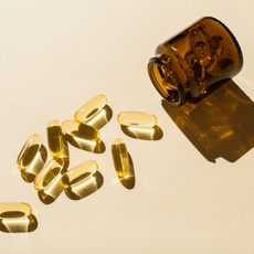 NAD+ capsules and a glass bottle on a beige background