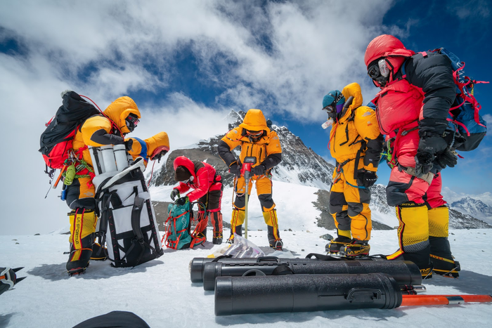 Researchers drill the highest ice core ever recovered at 27,000 feet elevation with the summit of Mount Everest in the background.